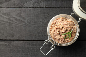 Glass jar of pate on dark wooden background