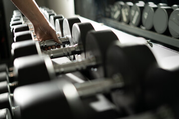 Naklejka na ściany i meble female hand takes a dumbbell in the gym. sport and healthy lifestyle concept.
