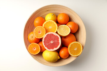 Bowl with citrus fruits on white background