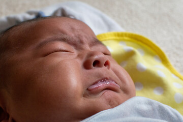 A Japanese Asian infant baby cries on the floor