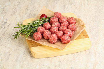 Raw uncooked beef meatballs served rosemary