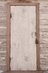 An old wooden door with a closed iron padlock
