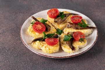 Sandwiches with sprats, cheese and cherry tomatoes in the form of hearts on brown background, Idea for Valentine's Day