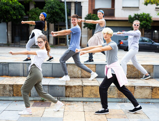 Group of dancing teenagers posing at city street. Hip hop dancers