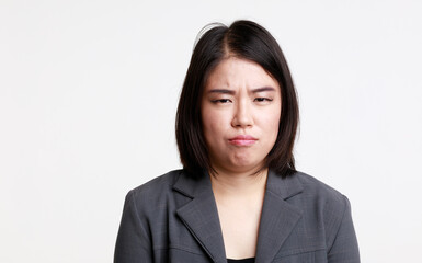 Portrait studio isolated cutout closeup head shot of Asian young moody sad upset unhappy stressed depressed frowning face female businesswoman in formal suit jacket look at camera on white background