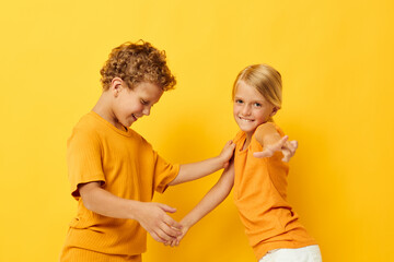 Boy and girl casual wear games fun together posing on colored background