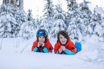Fototapeta na wymiar Happy preteen children on ski slope, enjoying snow
