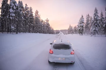 Rolgordijnen Car driving on icy snow covered roads on a road trip while travelling in Lapland inside the Arctic Circle in Finland © Matthew