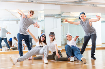 Fototapeta na wymiar Group of teenagers in casual clothes training hip-hop in class, posing and having fun
