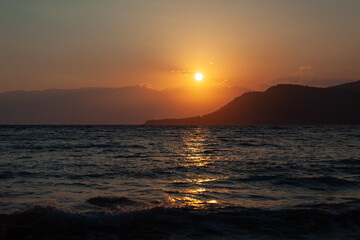 Sunset by the sea, the sky is reflected in the sea