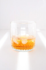 a glass of whiskey on a white background. The sun's rays on a white background.