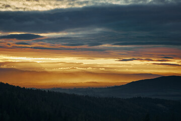 Fototapeta na wymiar Sunset with dramatic cloudy sky over mountains shape, beautiful nature landscape