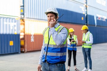 Foreman using radio walkie talkie control loading containers box in cargo for import export, Professional engineer work checking loading containers box.
