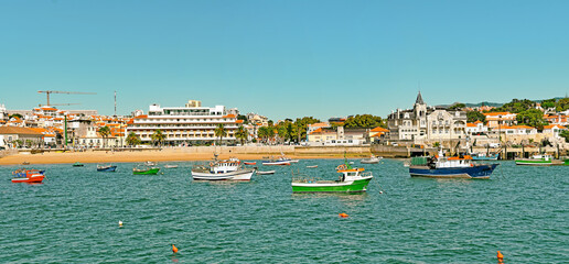 Panoramic view of sandy bay from city - Cascais, portuguese coast at Atlantic. Fishing boat with...