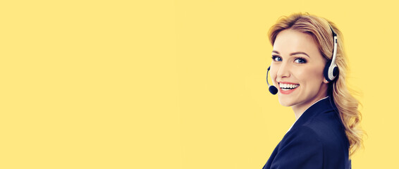 Call center. Smiling female support phone operator in headset, in confident suit, isolated over yellow background. Customer service help consulting. Copy space area for text. - obrazy, fototapety, plakaty
