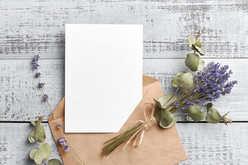 Invitation or greeting card mockup with lavender and eucalyptus flowers on wooden background