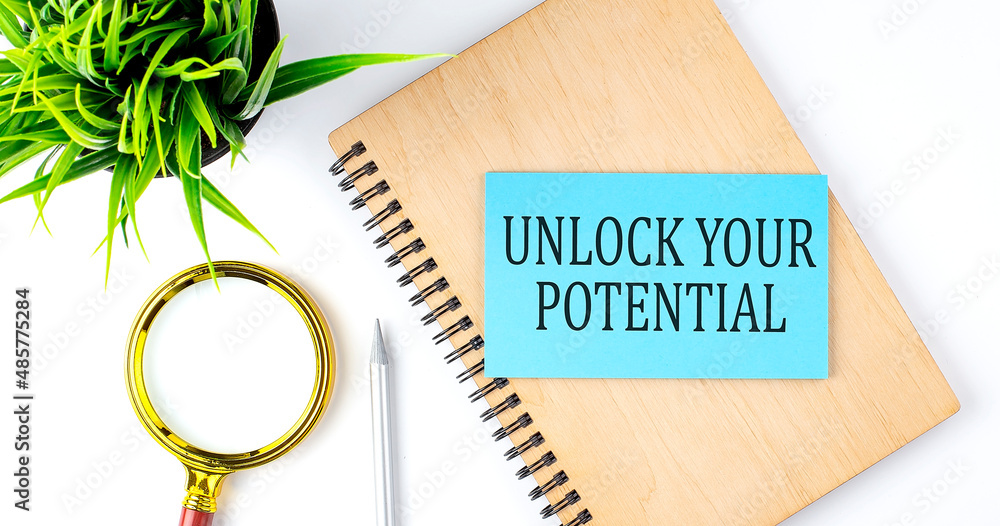 Poster notebook with tools and notes with text on the blue sticker unlock your potential
