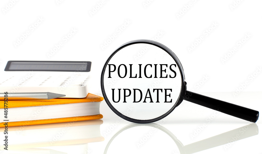Aufkleber magnifier with text policies udate with notebook, calculator on white background