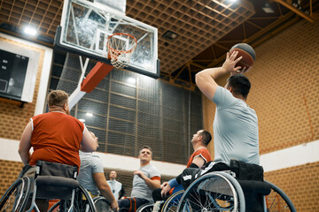 Handicapped player shooting at the hoop during wheelchair basketball sports match.