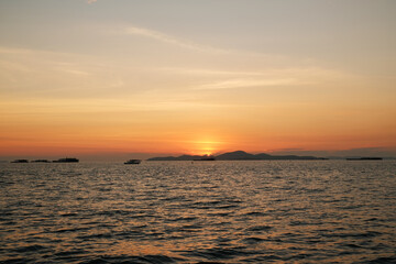 Fototapeta na wymiar Beautiful tropical orange sunset at sea in Thailand