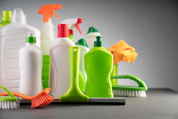 House  and office cleaning products. White and green cleaning kit on gray background.