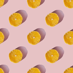 Uniform pattern of dried lemon slices with shadow on a pink background. Flat lay - obrazy, fototapety, plakaty
