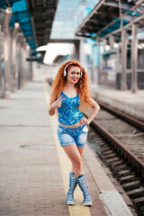 Obraz premium Beautiful African American woman using mobile phone, communication, looking at digital screen, walking on the street. Stylish hipster girl holding smartphone, listening to music, smiling outdoors