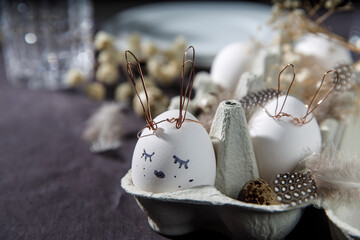 Easter concept. A white egg with copper wire ears and a painted rabbit sleeping face in a box....