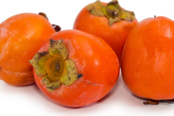 Persimmon fruits on white background, close-up in selective focus
