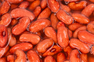 Red kidney beans soaked in water before cooking, close-up