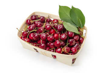 Dark red sweet cherries on stalks in the wooden basket