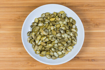 Top view of peeled pumpkin seeds on a saucer