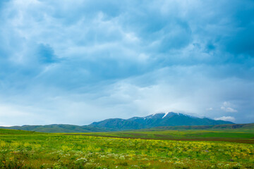 Fototapeta premium Panoramic view of the mountains in the distance, blue storm clouds over the mountains, cyclone, storm warning. Beautiful nature landscape. The freshness of the mountain air.