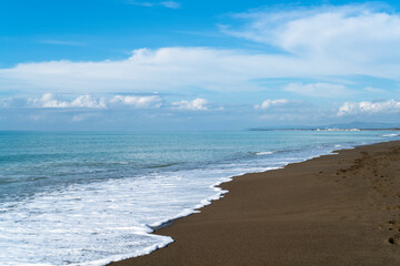 Sand beach with blue sea and blue sky and white cloud blurred at the coast