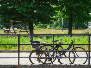 two bicycles parked near metal fence in a city