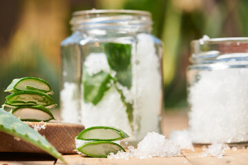 Fresh aloe vera leaf and vera gel on rustic wooden table background.