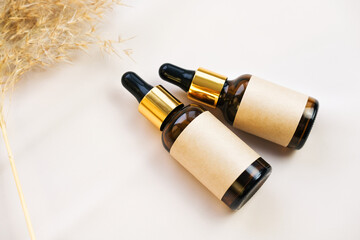 Glass cosmetic bottles with blank labels for branding mockup. Natural beauty product concept. Side view, space for text.