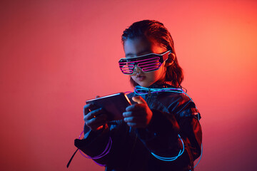 portrait cyberpunk boy child in neon glasses in blue and red tones with wires on a red background