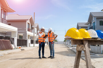 Engineers talking with builders and using laptop and blueprint to discuss about project at construction site,Architecture concept,New house builder.