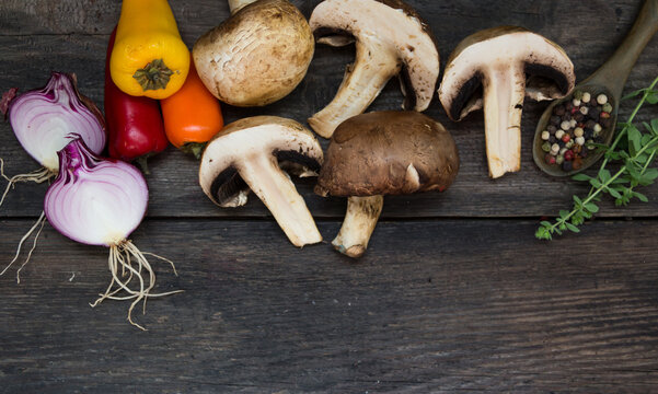 champinion mushrooms and fresh vegetables from the organic garden, on a rustic background