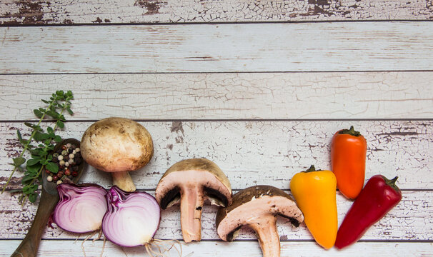 champinion mushrooms and fresh vegetables from the organic garden, on a rustic background
