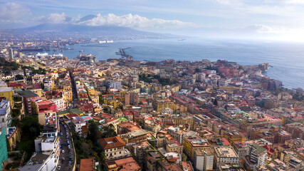 Aerial view of the city of Naples and the harbour on a sunny day. The volcano Vesuvius in the background.