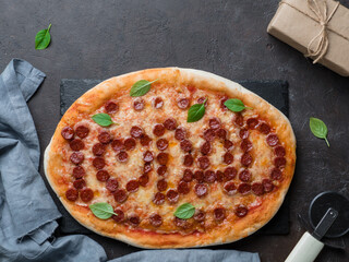 Father's day background. Pepperoni pizza with i love dad lettering and gift box on black table....
