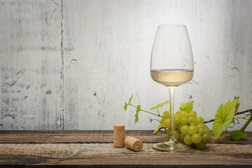 Glass of white wine on vintage wooden table..