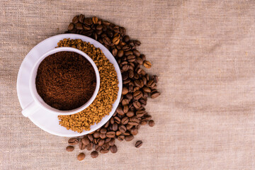 Coffee of different processing, ground, in grains and granules in a cup. View from above.
