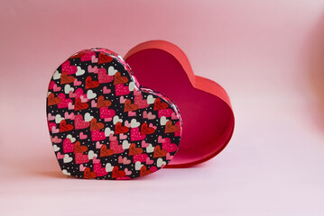 valentine's day. A gift box in the shape of a heart on a pink background with a place to fill the copy space.