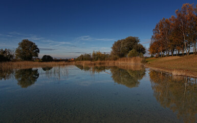 Fototapeta na wymiar Perfect water reflection of a fishing lake in the autumn, fall. 