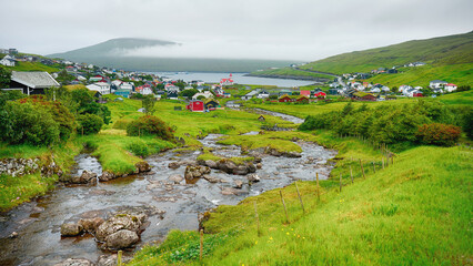 Fototapeta na wymiar Stunning views of the of the Stora River running through the beautiful village of Sandavagur located on the island of Vagar, Faroe Islands, Denmark.