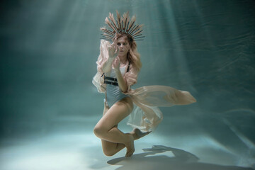 blonde underwater posing in a dress and crown