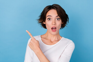 Portrait of amazed impressed crazy lady point finger blank space recommendation isolated on blue...